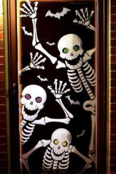Puerta con decoración de esqueletos halloween